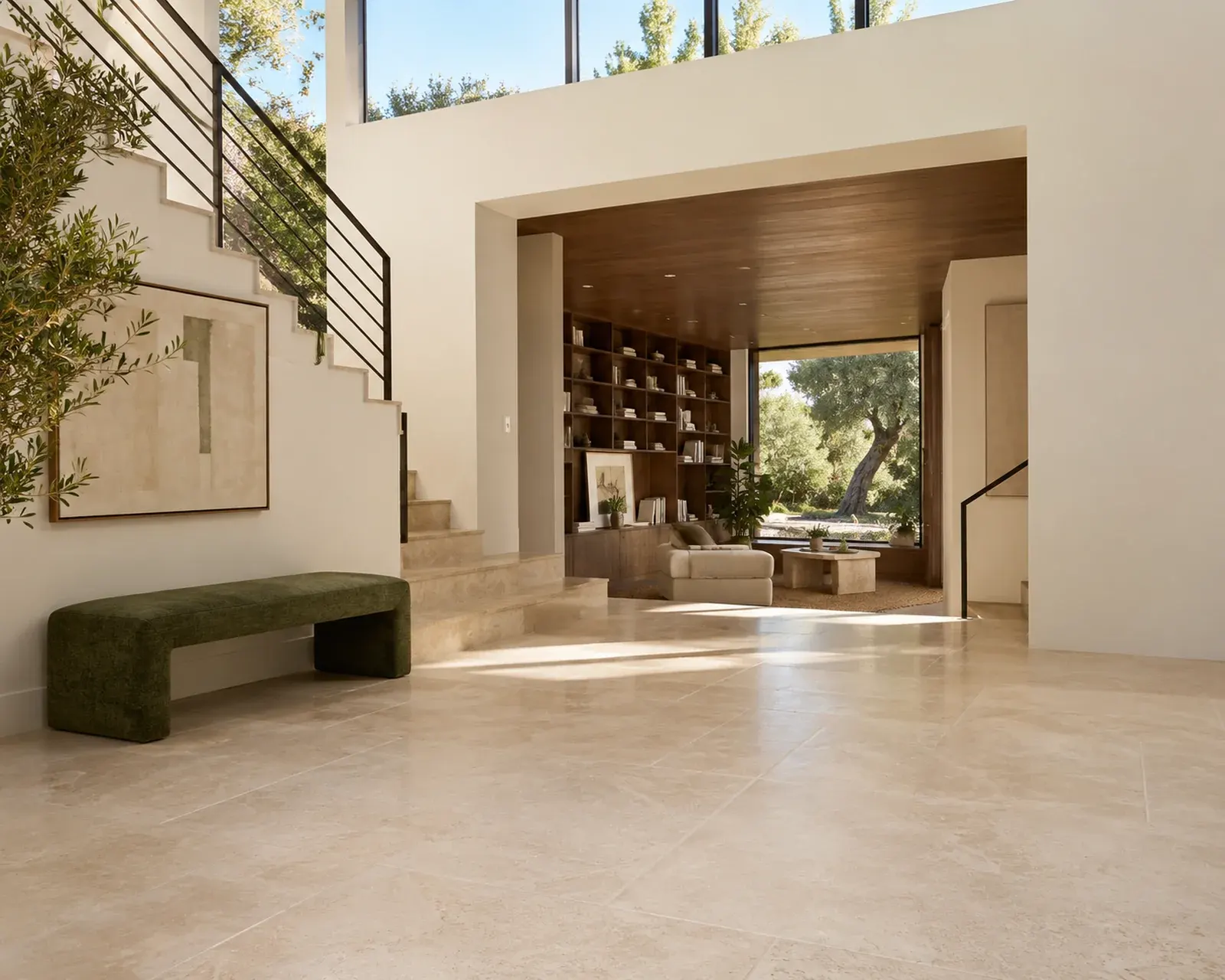 Entry hall with large-format limestone-look tile floor, floating staircase, green bench and an open living room beyond