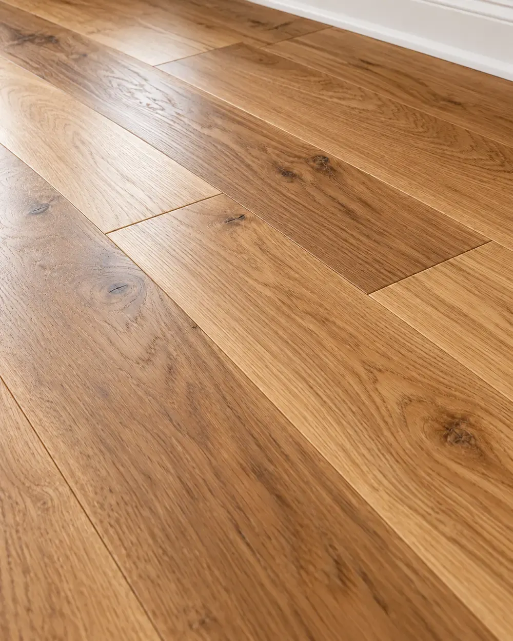 Hardwood flooring installation in Los Angeles: natural oak planks with a rich grain and white baseboard