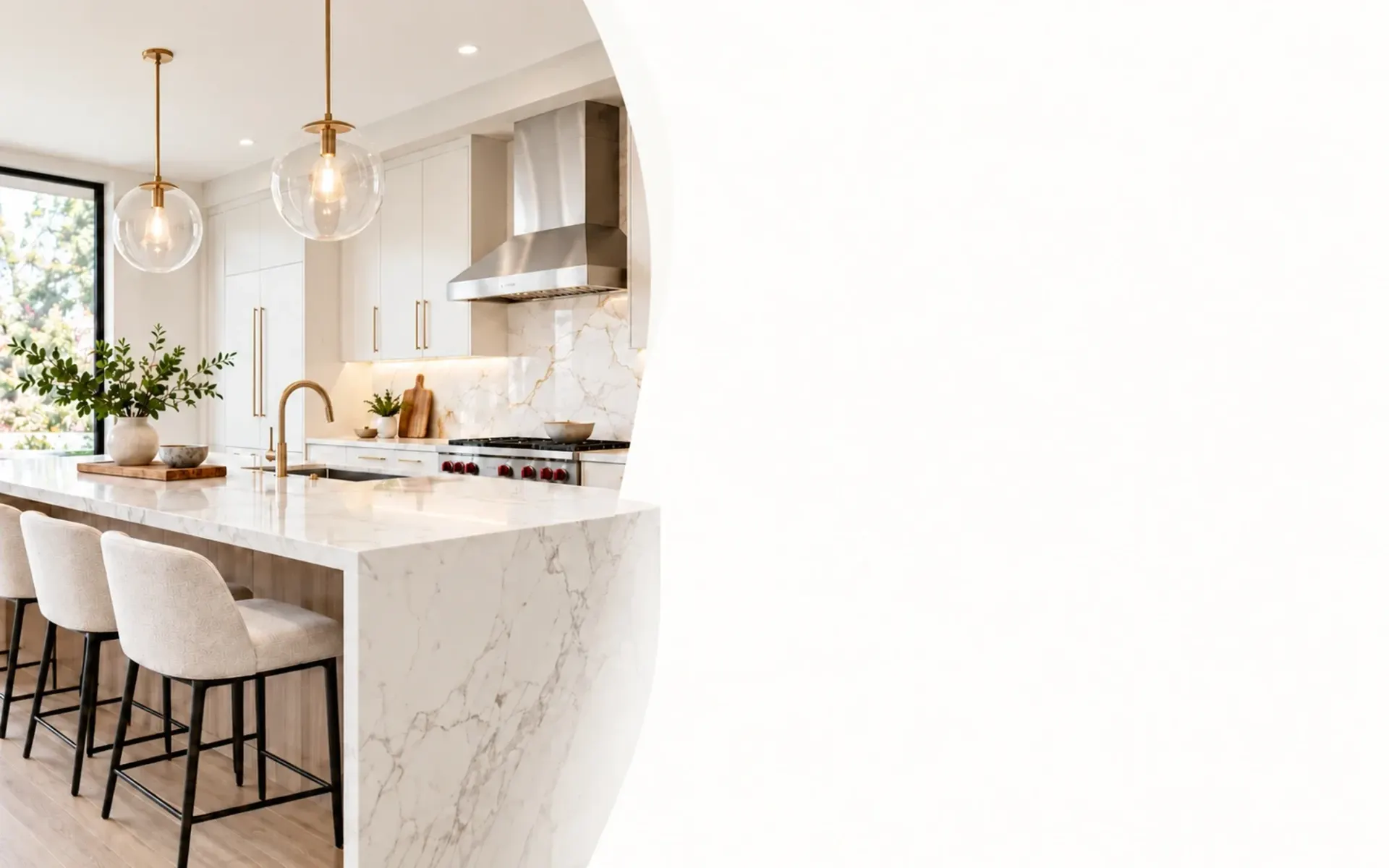 Bright remodeled kitchen in Los Angeles with marble waterfall island, glass pendant lights and brass faucet